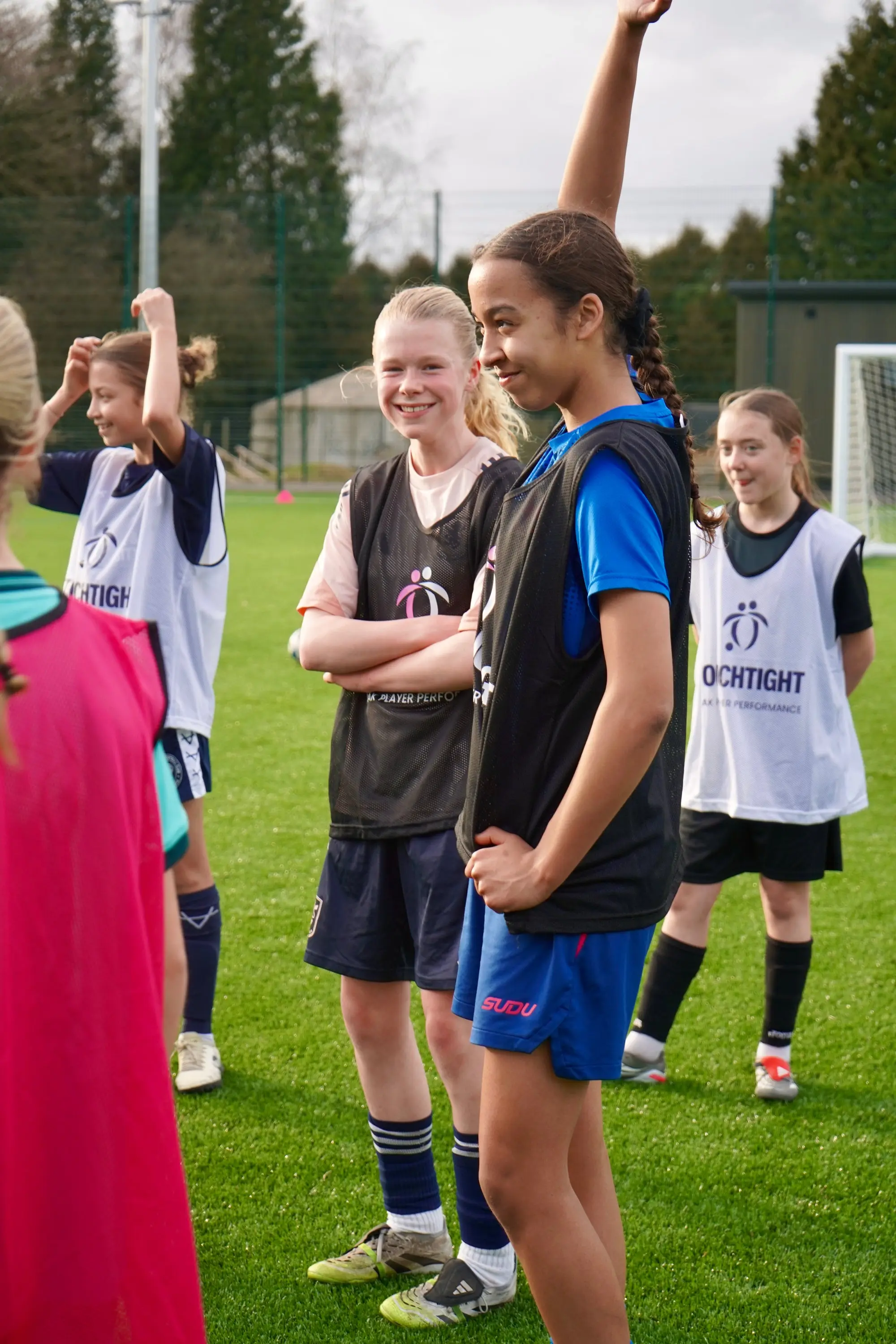 A group of girls in TouchTight bibs smiling together after a session